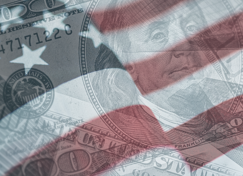 An American flag with an image of money over the flag.