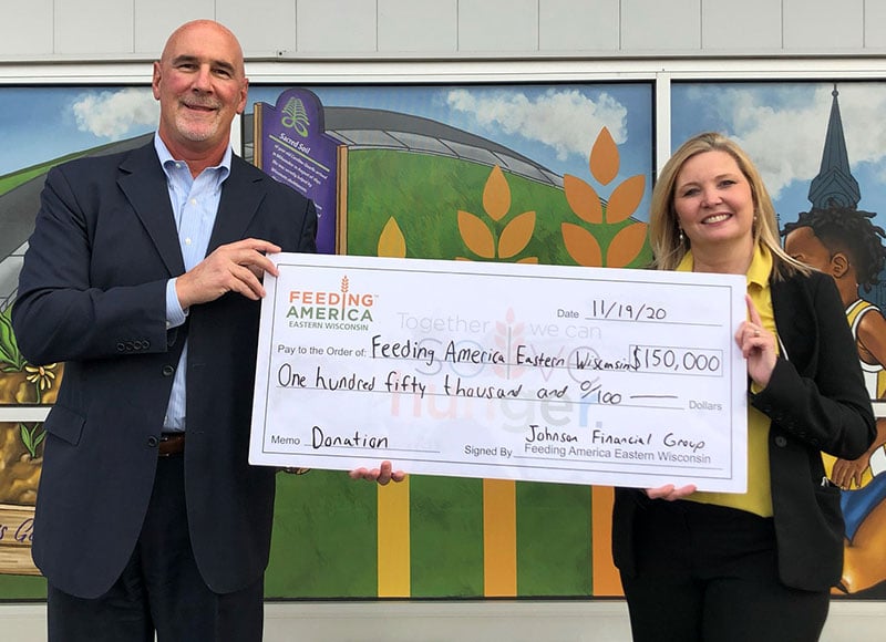 Jim and Patti hold a large check that JFG donated to Feeding America Eastern Wisconsin.